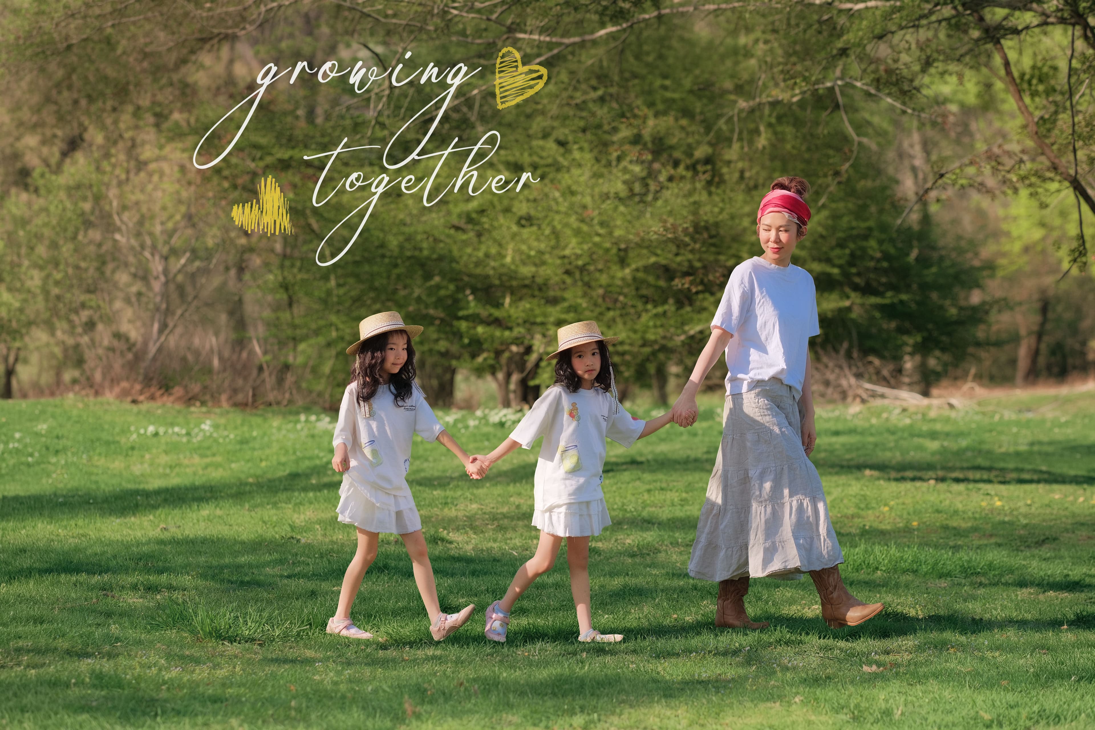 Mother in a white t-shirt and red headscarf standing beneath a blooming pink magnolia tree.